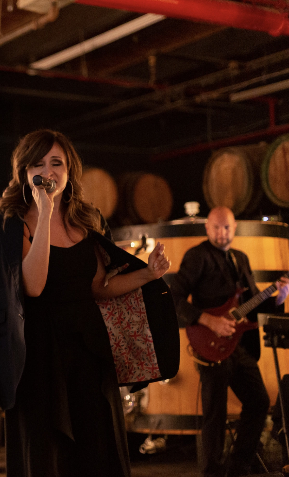 A live vocalist and guitarist performing in warm amber light